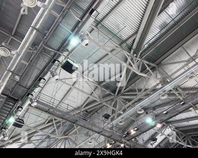 Lights and ventilation system in long line on ceiling of the  industrial building. Exhibition Hall. Ceiling factory construction Stock Photo