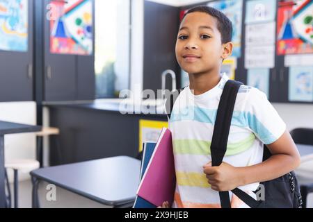 A biracial boy stands confidently in front of blue lockers Stock Photo ...