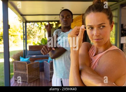 A diverse young couple, standing outside, showing off ring Stock Photo