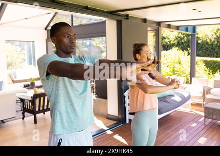 A diverse young couple practicing yoga outside Stock Photo