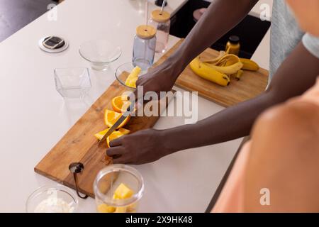 A diverse couple at home preparing breakfast, enjoying morning kitchen activities Stock Photo