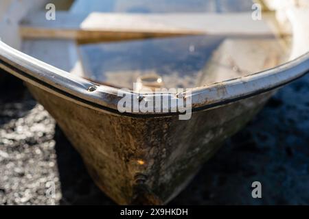 Ropes and chains of old dingy boat on the sandy shore line Stock Photo