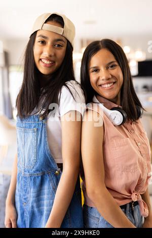 Biracial young sisters smiling at home, enjoying sunny day Stock Photo