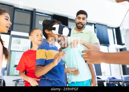 In school, young students and their Asian teacher are exploring virtual reality Stock Photo