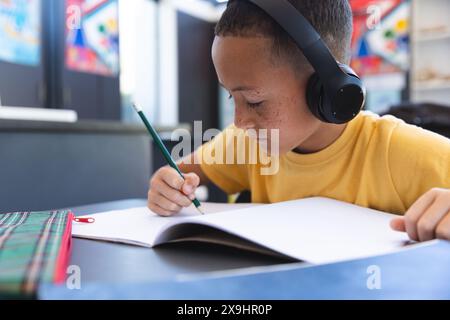Biracial boy studies intently at school Stock Photo