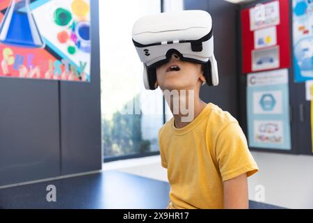 Biracial boy explores virtual reality in a school setting Stock Photo