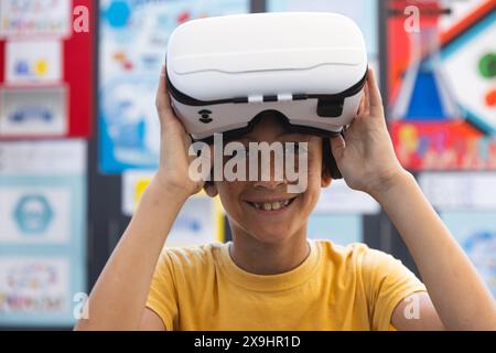 Biracial boy tries on virtual reality headset in school Stock Photo