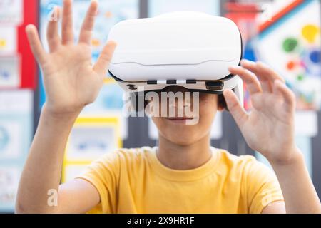 Biracial boy explores virtual reality at school Stock Photo