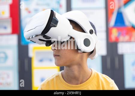 Biracial boy explores virtual reality at school Stock Photo