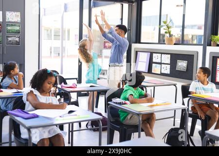 A diverse group of students learn from Asian male teacher Stock Photo