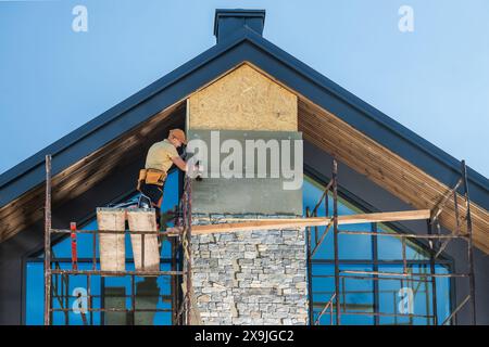 Construction Worker Installing Stone Veneer on a Modern Home Stock Photo