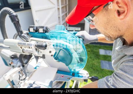 Man Operating a Miter Saw in a Yard Stock Photo