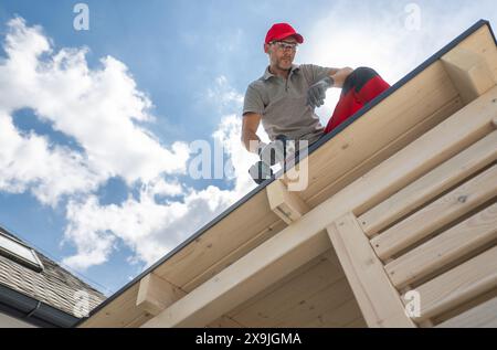 Professional Construction Worker on Roof Using Drill Stock Photo