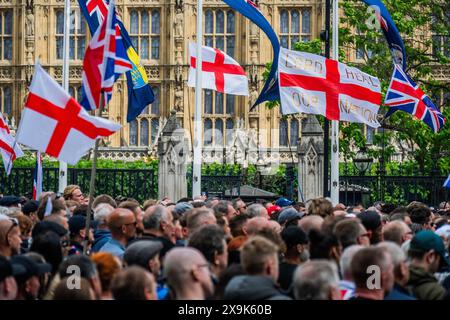 London, UK. 1 Jun 2024. A rally in Parliament square with a mix of flags including Israeli, pro Trump, the Cross of St George and the Saltire - Tommy Robinson (real name Stephen Lennon) marches with supporters to Parliament Square to screen his latest ‘documentary’, this time focusing on the supposed two-tier policing system in the UK that, he argues, treats Muslims and pro-Palestine demonstrators better than non-Muslim Brits. Credit: Guy Bell/Alamy Live News Stock Photo