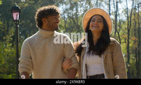 Carefree married multiethnic couple Hispanic woman girl African American man boy walking point finger hold hands. Female wife male husband smile Stock Photo