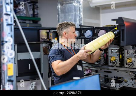 Maintenance engineer in a in printing house fixing machine Stock Photo