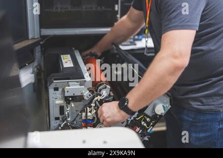 Maintenance engineer in a in printing house fixing machine Stock Photo
