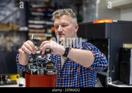 Maintenance engineer in a in printing house fixing machine Stock Photo