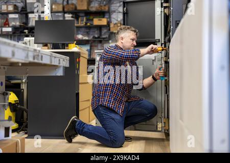Maintenance engineer in a in printing house fixing machine Stock Photo