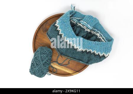 flat lay photography of a teal turquoise white wool yarn knitting on a wooden needles with yarn balls on a white background, stockinette stitch knitte Stock Photo
