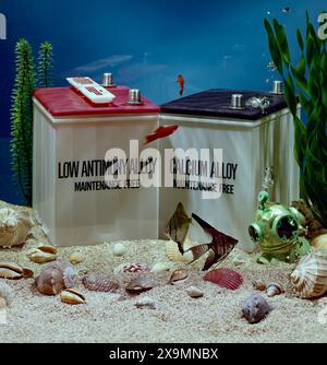 Automotive batteries submerged in aquarium with fish and shells, conceptual image of power, sustainability, energy storage and environmental impact Stock Photo