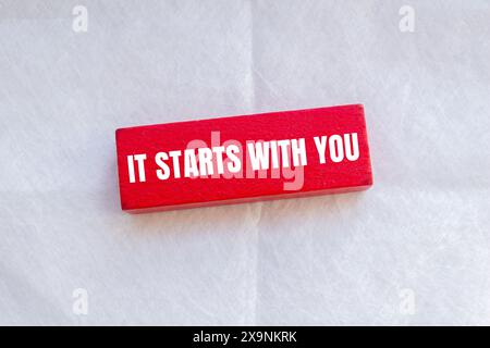 It starts with you words written on red wodoen block with white background. Conceptual it starts with you symbol. Stock Photo