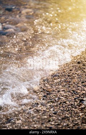 Beach with multicolored small round stones on a sunny day Stock Photo