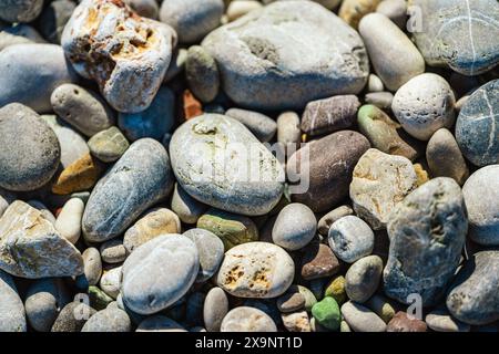 Beach with multicolored small round stones on a sunny day Stock Photo