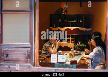 (240602) -- HUANGSHAN, June 2, 2024 (Xinhua) -- Customers drink tea beverages at a shop in Huangshan City, east China's Anhui Province, May 23, 2024. Wang Sun is the founder of Demingshe, a tea art vocational training school in Huangshan City. Huangshan City is the place of origin of several famous teas including Huangshan Maofeng, Taiping Houkui and Keemun black tea, and boasts a long history of drinking tea. As a pioneer in developing innovative tea-making skills and alternative ways of drinking tea, Wang started the research and promotion of the new-style tea beverages in 2021. Inspir Stock Photo