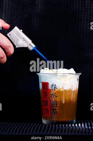 (240602) -- HUANGSHAN, June 2, 2024 (Xinhua) -- Wang Sun makes a tea beverage at Demingshe, a tea art vocational training school in Huangshan City, east China's Anhui Province, May 23, 2024. Wang Sun is the founder of Demingshe, a tea art vocational training school in Huangshan City. Huangshan City is the place of origin of several famous teas including Huangshan Maofeng, Taiping Houkui and Keemun black tea, and boasts a long history of drinking tea. As a pioneer in developing innovative tea-making skills and alternative ways of drinking tea, Wang started the research and promotion of th Stock Photo