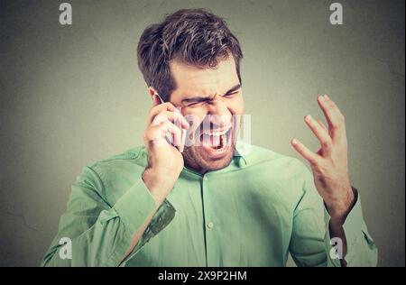 Furious business man screaming on the phone Stock Photo