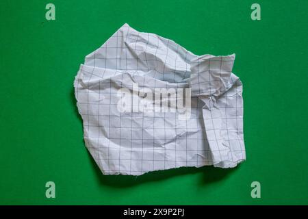 Ripped graph paper piece on green background, top view Stock Photo