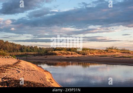 Wooden bridge over Lilaste river on Baltic sea beach Stock Photo