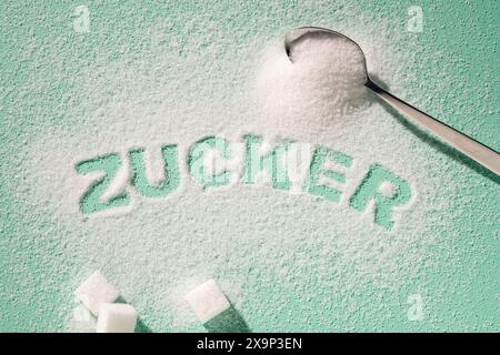 The German word Zucker written with sugar on a turquoise background Stock Photo