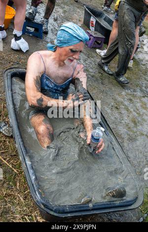 Promenade Park, Maldon, Essex, UK. 2nd Jun, 2024. Large numbers of runners tackled the gruelling course which took them across the River Chelmer and back at low tide, through the clinging, slippery mud. The Maldon Mud Race competitors run for charity, with many in fancy dress and all get covered in the slimy mud during the race, especially those further back once the mud becomes churned up. Participant in fancy dress bathing at the finish Stock Photo