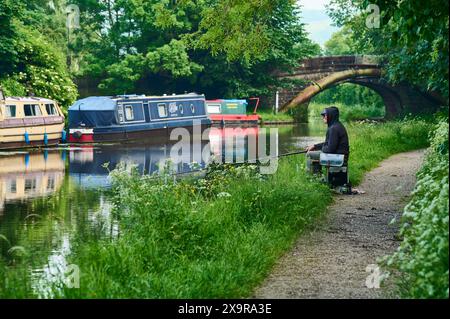 Angler on the tow path of the Lancaster canal on a spring day Stock Photo