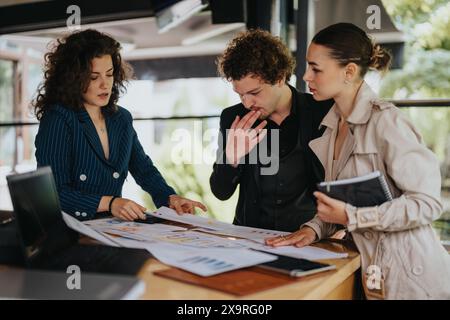 Young business partners working remotely at urban coffee bar, analyzing reports and creating marketing strategies Stock Photo