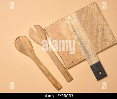 Empty wooden vintage fork and spoon with long handle, top view. Stock Photo