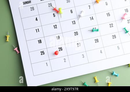 Timetable. Calendar page with drawing pins on green background, top view Stock Photo