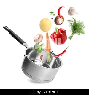 Fresh ingredients falling into saucepan on white background Stock Photo