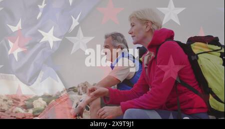 Image of flag of united states of america over senior couple taking break hiking in mountains Stock Photo