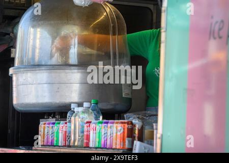 Street vendor mixing raw cookie dough in a large commercial blender or mixer vat Stock Photo