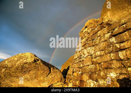 A rainbow is seen at the summit of Sharp Top mountain at sunset in the Blue Ridge Mountains of Virginia. Stock Photo