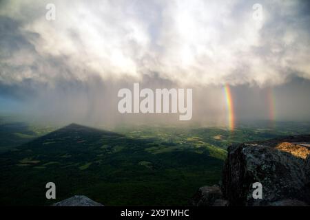 A rainbow is seen from the summit of Sharp Top mountain at sunset in the Blue Ridge Mountains of Virginia Stock Photo