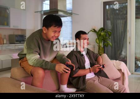 Father and son spending weekend at home playing videogame Stock Photo