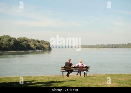 couple sitting on bench on Danube River in Apatin, Vojvodina, Serbia Stock Photo