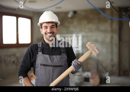 Front view portrait of a happy construction worker posing in a house under renovation Stock Photo