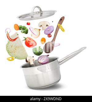 Fresh ingredients falling into saucepan on white background Stock Photo
