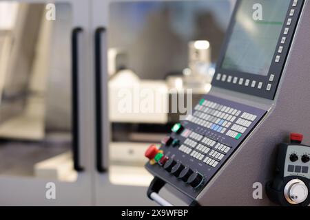 CNC control console and handheld remote controller of metalworking machining center. Selective focus. Stock Photo