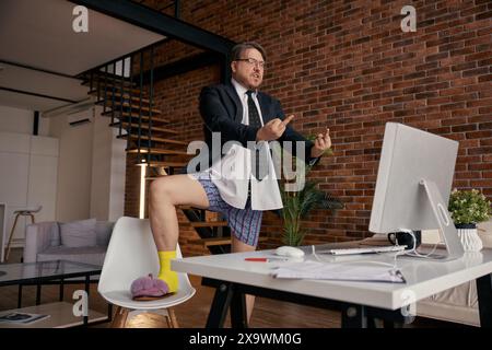 Crazy businessman showing middle finger at computer screen during remote work Stock Photo